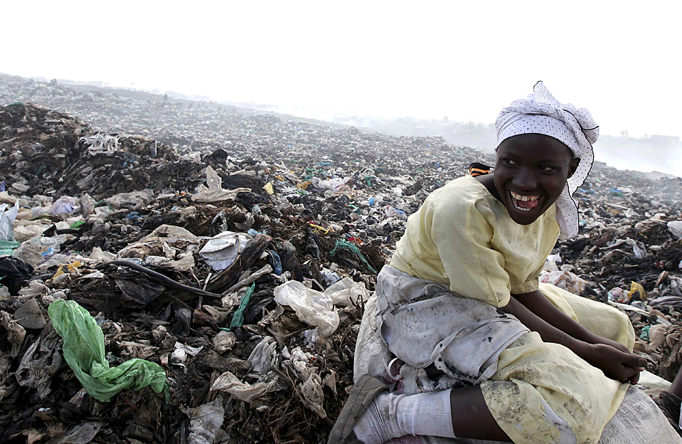 A woman takes a break from scavenging for recyclable materials at the Dandora Municipal Dumping Site in Kenya's capital Nairobi December 10, 2009. The dumping site was declared full and a health hazard for the neighbouring population in 2001 but chemical, hospital, industrial, agricultural and domestic waste are still dumped here and left unprocessed. A study commissioned by the Nairobi-based U.N. Environment Programme (UNEP) found that half of 328 children tested around the site had lead concentrations in their blood exceeding the internationally accepted level. REUTERS/Thomas Mukoya (KENYA ENVIRONMENT HEALTH SOCIETY IMAGES OF THE DAY)
